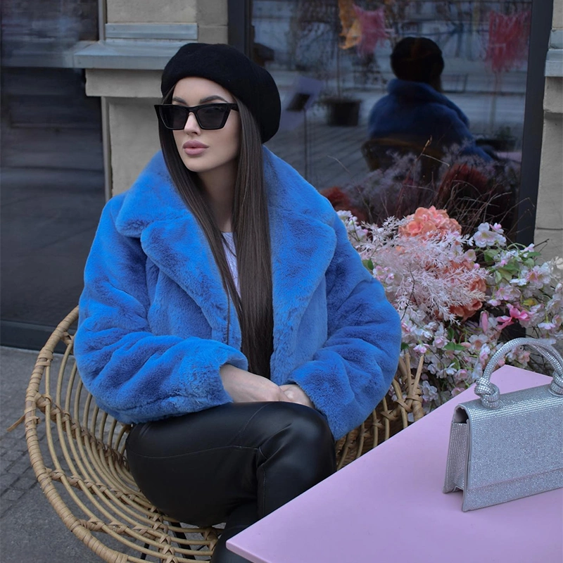 femme dans un café avec veste fausse fourrure bleu